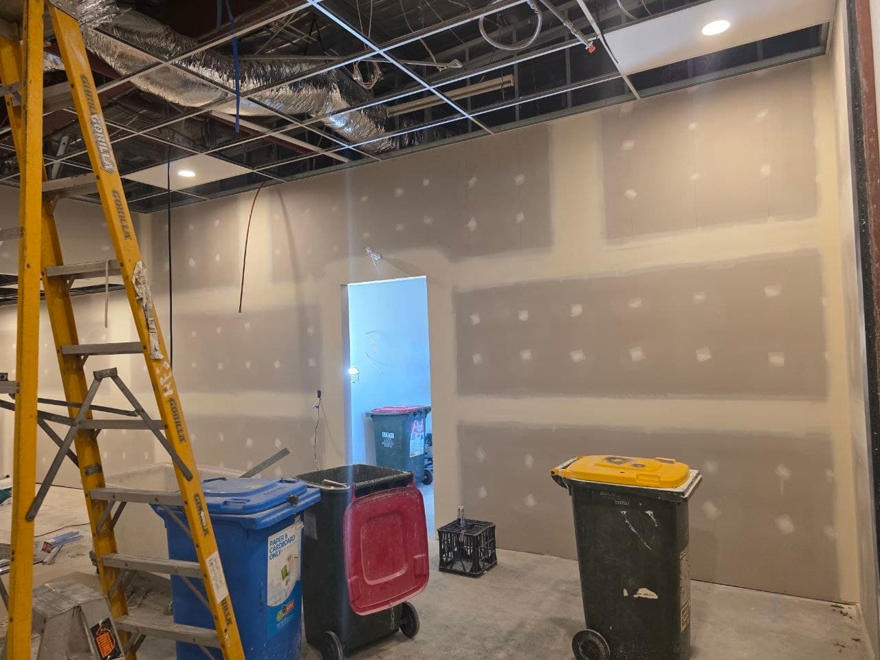Unfinished studio walls with exposed ceiling grid